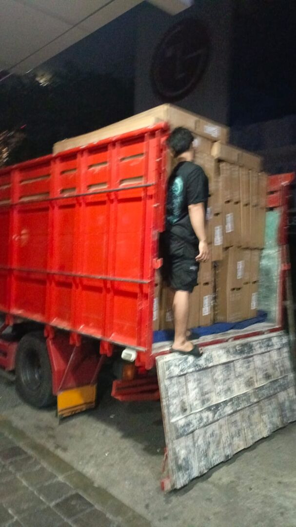 Truk dimuat penuh dus TV pada malam hari, menyesuaikan jam operasional gedung